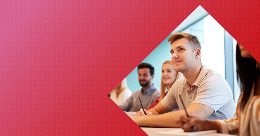 Image of workplace setting. One person is in the foreground of the image holding a pen on a desk. Find out how to contact the Recordati Rare Disease team for general enquiries, medical information or to report an adverse event